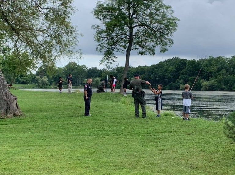 Niagara County, New York, police officers fishing with a group of kids.
