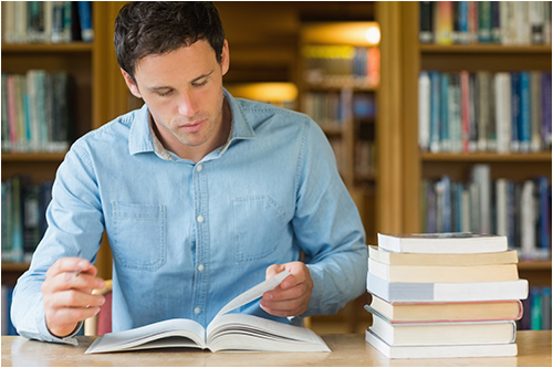 Man Studying in a Library (Stock Image)