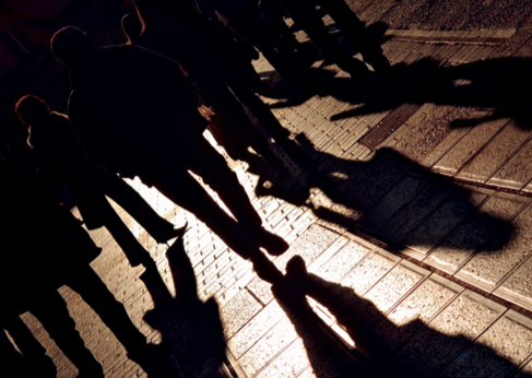 Angled Silhouettes and Shadows of People Walking (Stock Image)