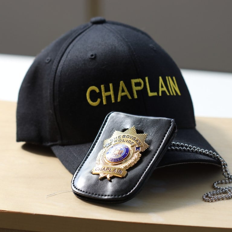 A photo of a chaplain hat and police badge.
