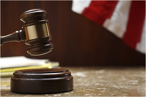 Gavel with Flag in Background (Stock Image)