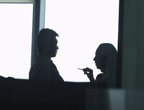Silhouette of a Man and Woman Talking Near Window (Stock Image)