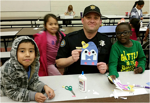 Community Police Officer Kerby Tonalea Working on Penguin Art Craft Project with Kids
