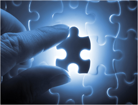 Fingers Holding Glowing Puzzle Piece (Stock Image)