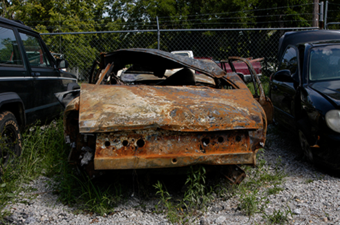Rusty Car in Gated Lot