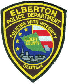 The traditionally shaped patch of the Elberton, Georgia, Police Department prominently features the city’s seal in its center. The middle depicts an outline of Elbert County, for which Elberton is the seat of government, along with a smaller outline of the state. The red and white stripes against a blue background with stars embody the patriotic sentiments of the community. At the foreground of the seal is a representation of the city’s churches, courts, and granite industry. Elberton is considered the “Granite Capital of the World,” producing more granite products annually than anywhere else.