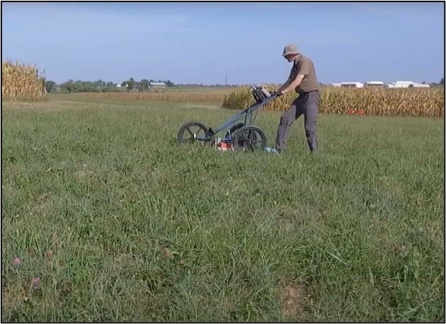 A forensic scientist using a ground penetrating radar.
