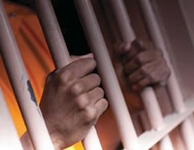 Hands Grasping Prison Bars (Stock Image)