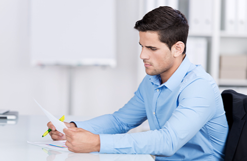 Man Reading Document and Highlighting (Stock Image)