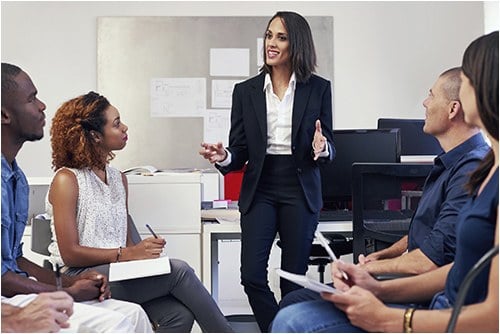 Woman Talking to Co-Workers (Stock Image)