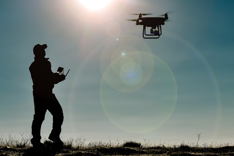 A stock image of a man flying a drone.
