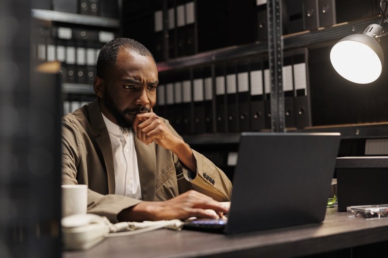 A stock image of a man looking at a laptop.