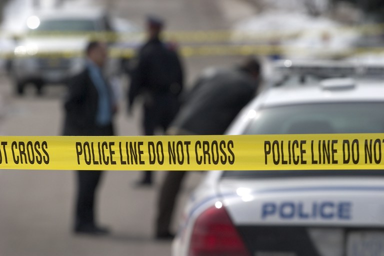 A stock image of crime scene tape and police officers.