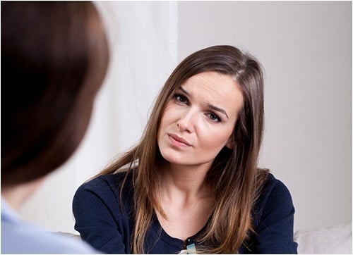 Woman Listening to Another Person (Stock Image)