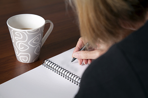 Woman Writing in Notebook (Stock Image)