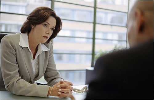 Stock image of a manager talking to a co-worker in her office.