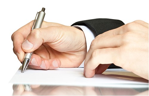 Man Writing a Note with a Pen (Stock Image)