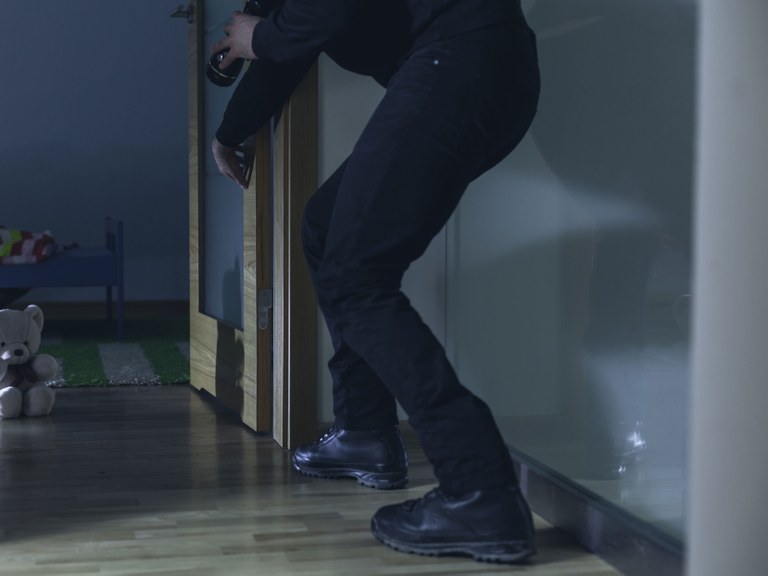 Stock image of a man at the door of a child's bedroom at night.