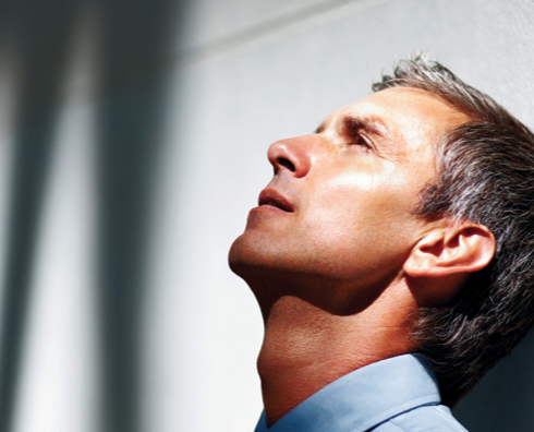 Man Leaning Head Back Against Wall and Looking Up (Stock Image)