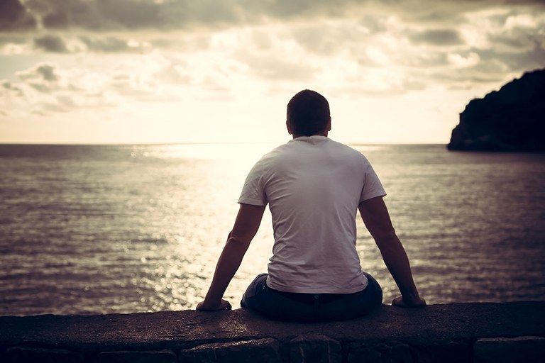 A stock image of male looking out towards the water.