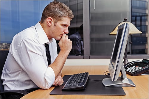 Investigator Sitting at Computer (Stock Image)