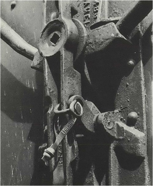 Boxcars are usually sealed with a small metal seal which provides proof-of-load security only. Some form of additional security is usually applied, and in this case, a 60-penny nail is applied to the door hasp to prevent easy entry. From the February 1977 Law Enforcement Bulletin.