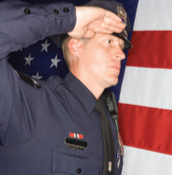 Officer Saluting with American Flag in Background