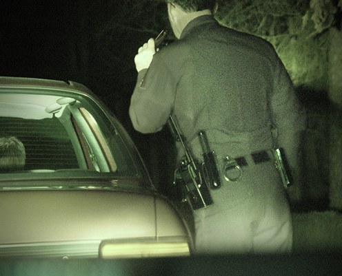 Officer Shining Flashlight Into Car