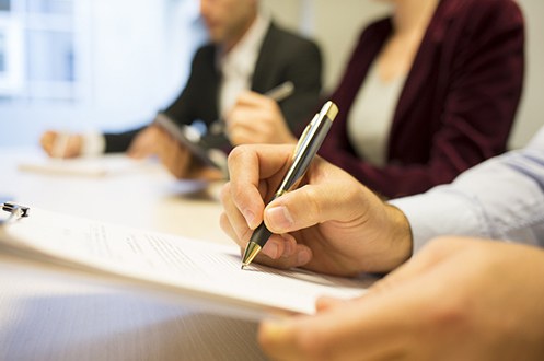 Person Taking Notes in Meeting (Stock Image)