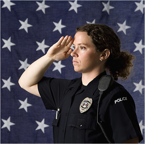Female Police Officer Saluting with Flag Backdrop