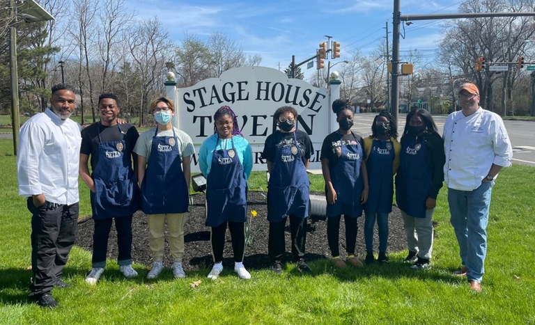 An outdoor picture of a group of young adults in the Cooking With Cops program