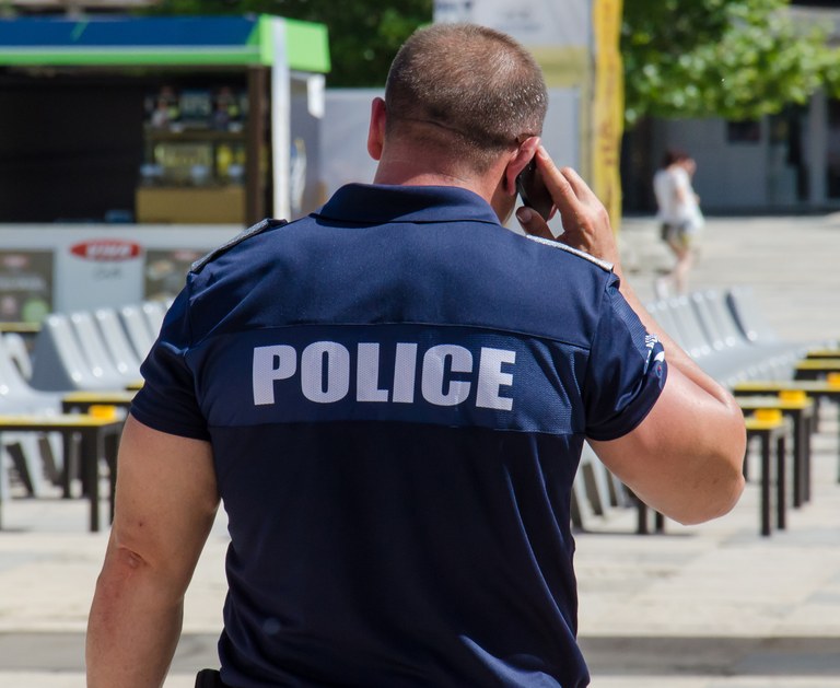 A stock image of a police officer talking on a cell phone.