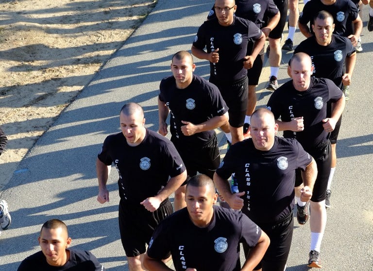 A stock image of police recruits running in two lines.
