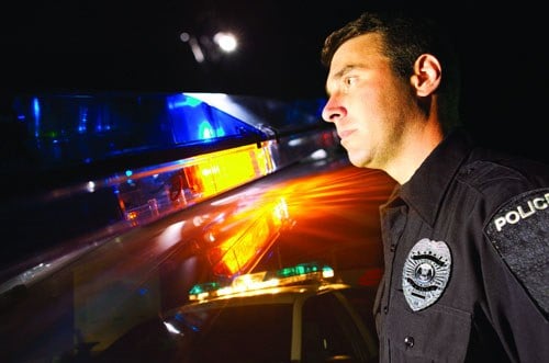 Depiction of a police officer patrolling the night.