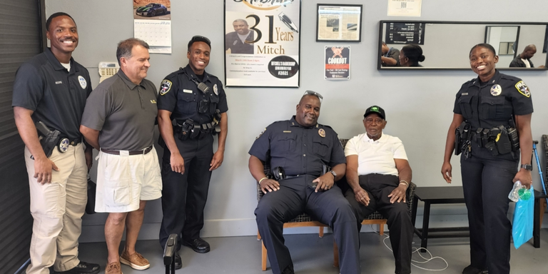 Group photo of Irving officers and customers at the barber shop.