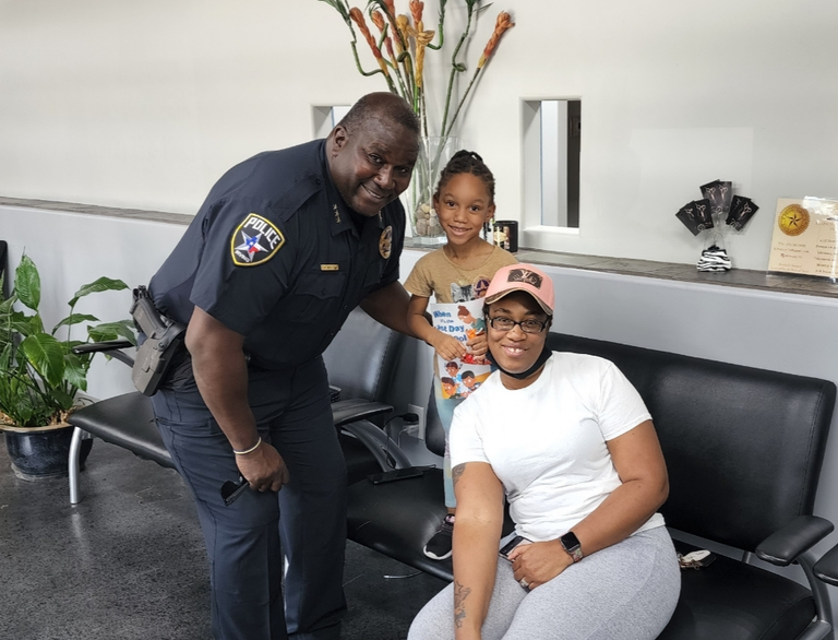 A photo of an Irving police officer and barber shop customers.