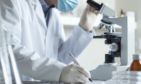 Scientist Looking in Microscope (Stock Image)