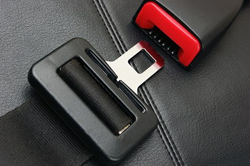 Stock image of a seat belt buckle inside of a vehicle. 
