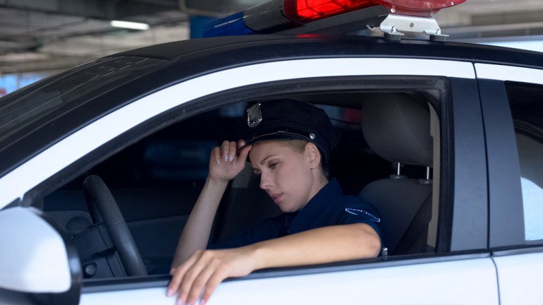 A stock image of a female officer in her patrol car.