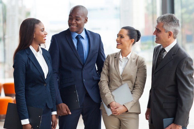 A stock image of a group of buisness men and women talking.