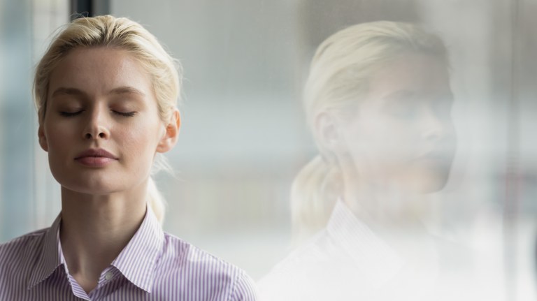 A stock image of a business woman with her eyes closed.