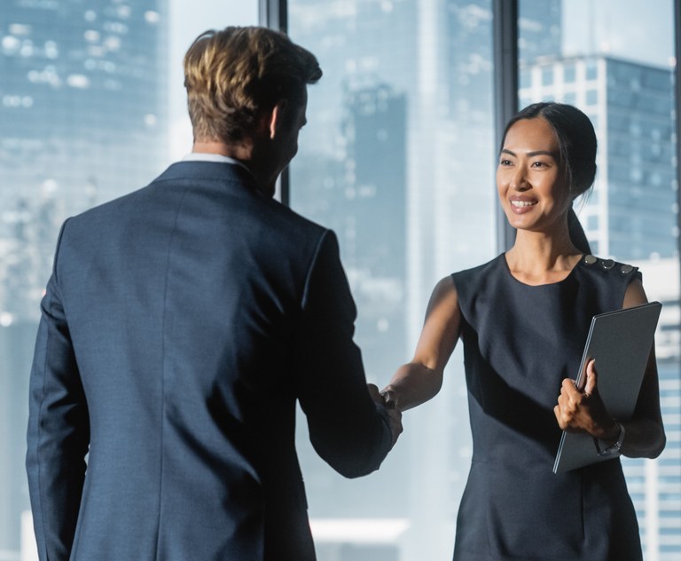 A stock image of two business people shaking hands.