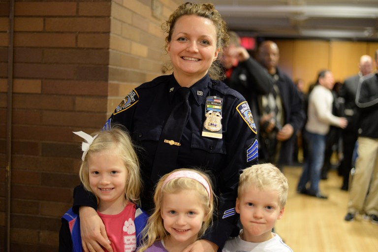 A stock image of a female police officer with her three children.