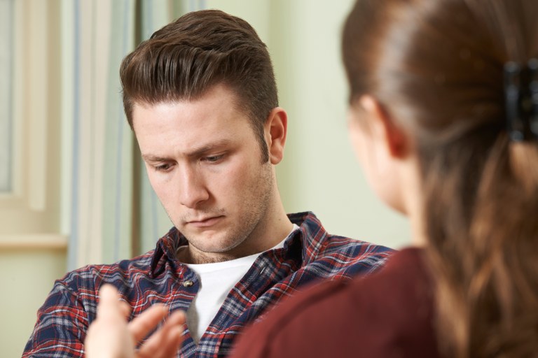 A stock image of a man listening to a female talking to him.