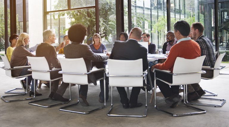 A stock image of a group of people in a meeting.