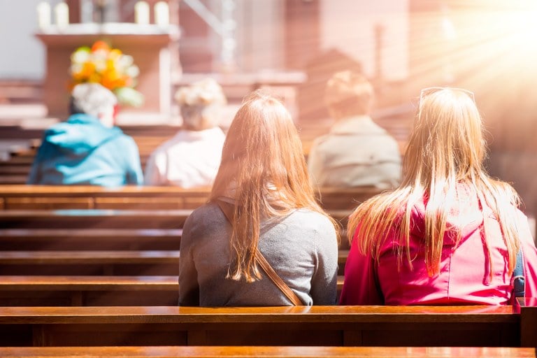 A stock image of people sitting in the pews at church.