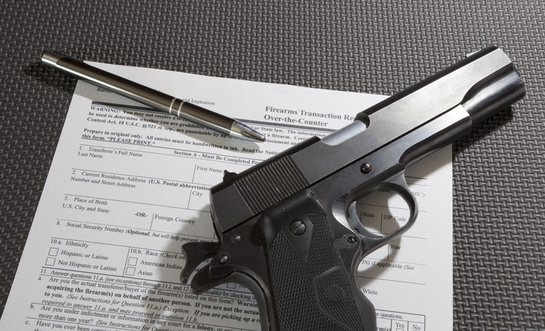 A stock image of a handgun placed on top of a firearms form.