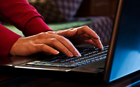 Woman's Hands Typing on a Laptop (Stock Image)