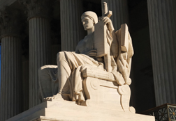 One of two statues seated adjacent to the front steps of the Supreme Court Building. © Photos.com