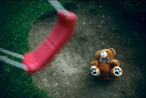 Teddy Bear Beneath Empty Swing (Stock Image)